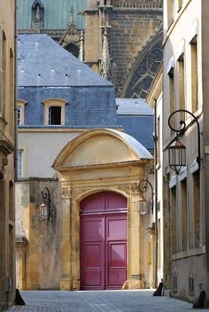 a red door in an alley between two buildings