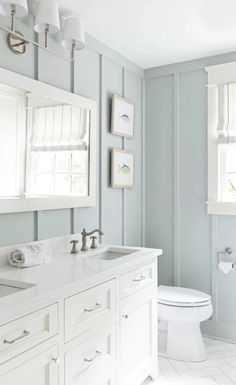 a bathroom with blue walls and white fixtures