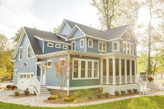 a blue house with white trim on the front and side windows is shown in this image