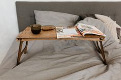 an open magazine is sitting on top of a coffee table in the middle of a bed