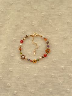 Bracelet Length: 6 inches  Each Bracelet has a 2 inch 14k gold filled extender This necklace features cream, red, orange, mustard, matte transparent brown, and 24k gold plated seed beads. It also contains cream, green, purple, crystal beads. As well as freshwater pearls, Amethyst, African Jade, sandstone, carnelian, fireagate, and copper spacer beads. Seed Bead Size: 11/0, 6/0, 2mm, 4mm, 6mm Fall Flower, Dope Jewelry, Funky Jewelry, Jewelry Lookbook, Flower Bracelet, Girly Jewelry, Jewelry Inspo, Dream Jewelry, Bracelet Handmade