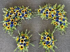 sunflowers and other flowers are arranged in the shape of an x on a gray surface