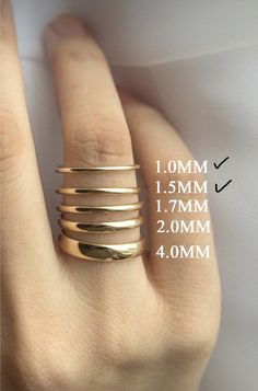 a person's hand with four different rings on it and measurements for each ring