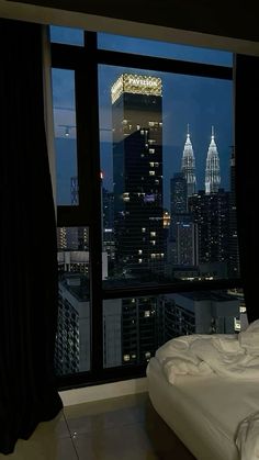 a bedroom with a view of the city at night