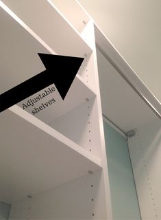 an arrow pointing to the opposite side of a white shelf with shelves on each side