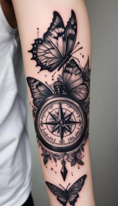 a tattoo with butterflies and a compass on the left side of the arm is shown