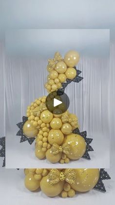 an image of balloons in the shape of a christmas tree with black and gold decorations