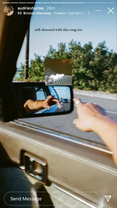 someone's reflection in the rear view mirror of a car as they drive by