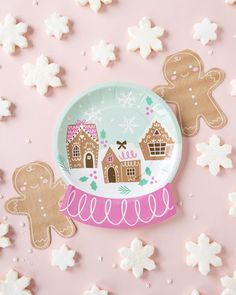 two paper plates with gingerbread cookies on them next to snowflakes and stars