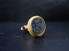 This vintage ring design features an engraved onyx with sphinx, a mythical creature with the head of a human, the haunches of a lion, and sometimes the wings of a bird. An apotropaic symbol offering protection to the wearer. A large hand-engraved black onyx with the sphinx figure and 3 garnet gemstones which decorate the ring band design. Onyx gemstone size: 15 x 14mm approx. → The ring is made of sterling silver 925. We can create this design for you in three different variations, depending on Signet Rings Women Vintage, Ancient Greece Jewelry, Goldsmith Workshop, Dragons And Dungeons, Greek Mythology Jewelry, Future Jewelry, Ancient Greek Jewelry, Mythology Jewelry, Silver Coin Ring