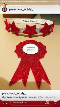 a red ribbon with stars on it and a name tag that says preschool acty