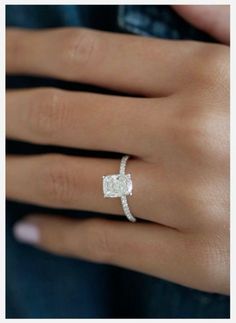 a woman's hand with a diamond ring on it