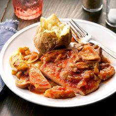 a white plate topped with meat and potatoes