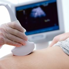 a person in white gloves is performing an operation on the back of a woman's stomach