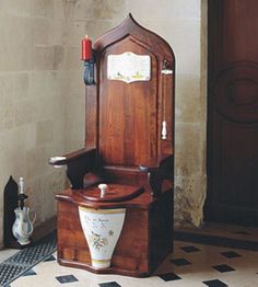 the toilet is made out of wood and has a wooden seat