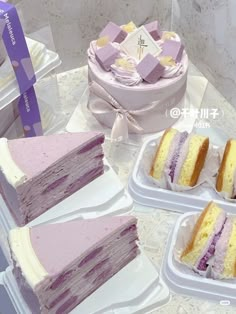 there are several different types of cakes on the table with plastic trays next to them