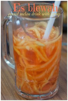 a glass mug filled with liquid sitting on top of a wooden table