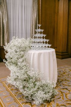 a table topped with a white cake covered in baby's breath