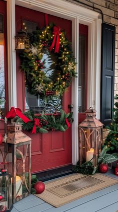 a red front door decorated with christmas wreaths and lights