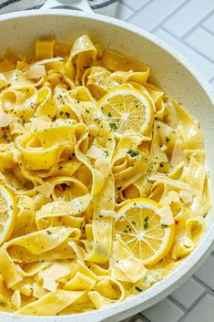 a white bowl filled with pasta and lemon slices