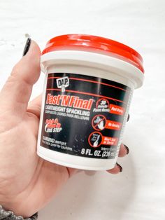 a hand holding a container of fast n'final waxing paste on a white surface