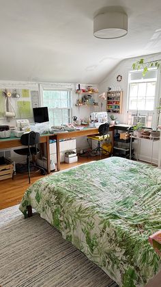 a bed sitting in a bedroom next to a desk with a computer on top of it