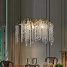 a chandelier hanging from the ceiling in a dining room with chairs and table