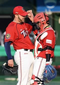 two baseball players standing next to each other