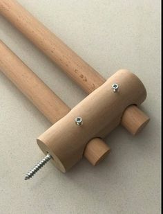 two wooden handles with screws attached to each other on a white surface, one is made out of wood and the other has metal studs