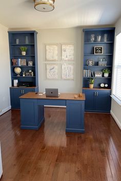 a home office with blue bookcases and wooden floors