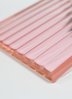 a close up of a pink plastic object on a white surface with black and red lines