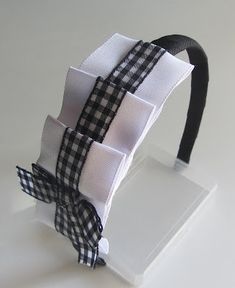 a black and white headband with a bow on the top is sitting on a stand