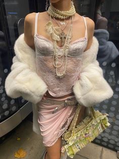 a mannequin dressed in pink and white clothing with pearls on her necklaces