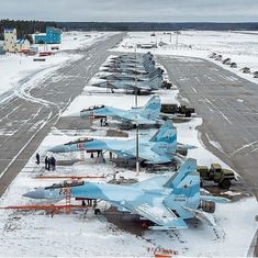 several fighter jets are parked on the snow covered runway