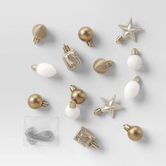 gold and white christmas decorations are arranged on a white surface, including starbursts