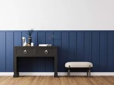 an empty room with a desk and chair in it, painted blue by the wall