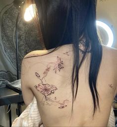 a woman with a flower tattoo on her back