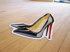 a pair of high heeled shoes sitting on top of a wooden floor