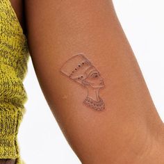 a woman's arm with a tattoo on it that has an egyptian mask on it