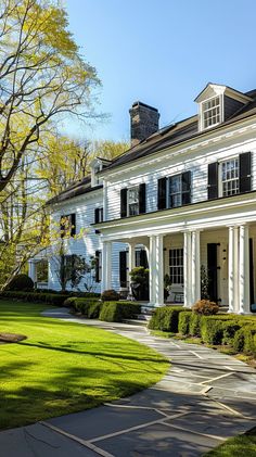 a large white house sitting on top of a lush green field