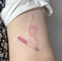 a small tattoo on the back of a woman's leg with a pencil in it