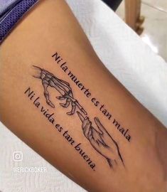 a woman's arm with two hands holding each other and the words in spanish on it