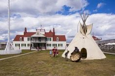 people are standing in front of a teepee