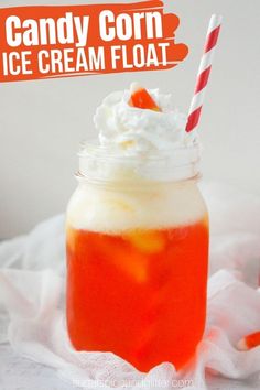 an orange drink with whipped cream and candy corn on top, in a mason jar