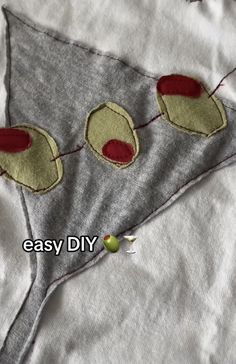 an embroidered piece of fabric with two apples on it and the words easy diy