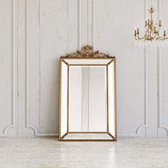 a mirror sitting on top of a white floor next to a chandelier