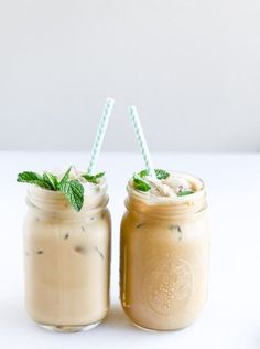 two mason jars filled with iced coffee and topped with minty garnishes