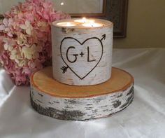 a candle that is sitting on top of a wooden stand with a heart drawn on it