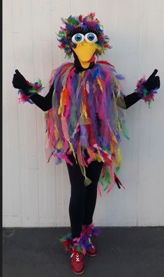 a person dressed up as a bird with feathers on it's head and arms