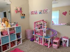 there is a doll house in the corner of this room with toys on the floor